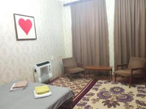 a room with a bed and chairs and a heart on the wall at room with a mountain view in Zugdidi