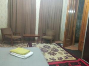 a hotel room with a bed and chairs and a mirror at room with a mountain view in Zugdidi +1 photo
