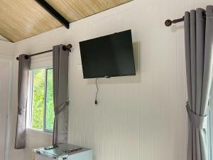 a flat screen tv on the wall of a room at Wildnest House in Ko Yao Noi