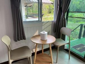 a small table and two chairs in front of a window at Wildnest House in Ko Yao Noi