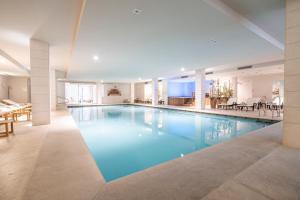 a large pool with blue water in a building at Splendido Bay Luxury Spa Resort in Padenghe sul Garda