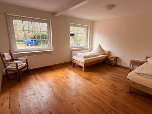 a bedroom with a bed and two windows at Haus an der Hase in Bramsche