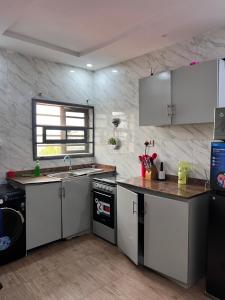 a kitchen with white cabinets and a counter top at Executive 2-Bedroom Apartment in Ikeja