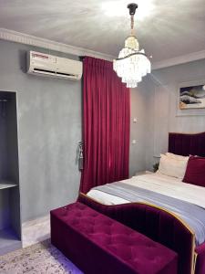 a bedroom with a bed with a red curtain at Executive 2-Bedroom Apartment in Ikeja