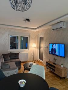 a living room with a couch and a flat screen tv at PRESTIGE apartman Krusevac in Kruševac