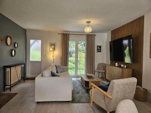 a living room with a couch and a tv at La fleur des eaux de Beauval in Noyers-sur-Cher