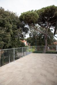 a metal fence with trees in the background at Villa Serena - Luminor Apartment in Tirrenia