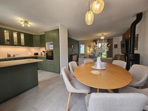a kitchen and dining room with a wooden table and chairs at La fleur des eaux de Beauval in Noyers-sur-Cher