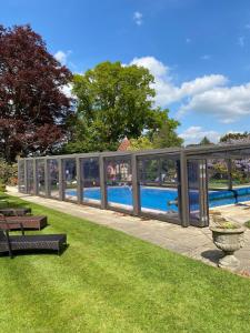 a long glass fence next to a swimming pool at Knowle Grange Guest House in Frant