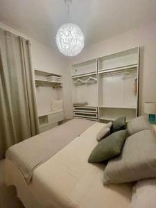 a bedroom with a large bed and a chandelier at Stella di Mare with Jacuzzi, Costa Smeralda in Arzachena