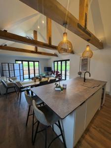 a kitchen and living room with a large island with chairs at Knowle Grange Guest House in Frant