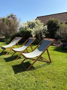 two lounge chairs sitting in the grass at Knowle Grange Guest House in Frant