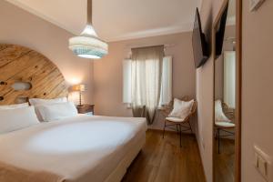a bedroom with a large white bed and two chairs at Aurora Boutique Hotel & Private SPA - Etruria Collection in Spoleto +73 photos