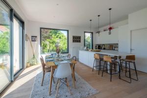 a kitchen and dining room with a table and chairs at Villa Mont d'or - Welkeys in Champagne-au-Mont-dʼOr