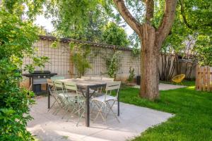 a table and chairs in a yard with a tree at Villa Mont d'or - Welkeys in Champagne-au-Mont-dʼOr