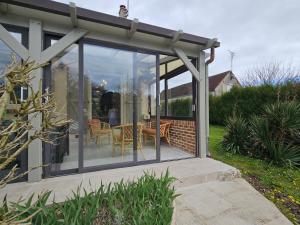 a conservatory with glass doors on a house at La fleur des eaux de Beauval in Noyers-sur-Cher
