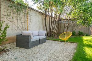 a couch and a yellow chair in a backyard at Villa Mont d'or - Welkeys in Champagne-au-Mont-dʼOr +19 photos