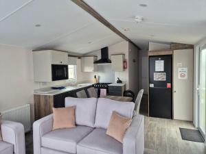 a living room with a couch and a kitchen at Red Lion Leisure Park in Arbroath