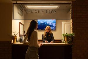 two women are standing at a reception desk at Aurora Boutique Hotel & Private SPA - Etruria Collection in Spoleto
