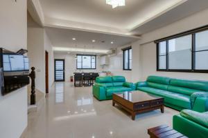 a living room with a green couch and a table at Le Wu Casa in Huxi