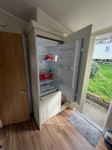 an empty refrigerator with its door open in a room at Sunshine Newquay Bay Resort in Newquay Bay Resort