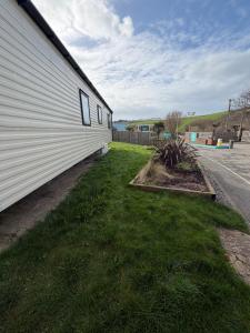a side of a building with grass next to it at Sunshine Newquay Bay Resort in Newquay Bay Resort