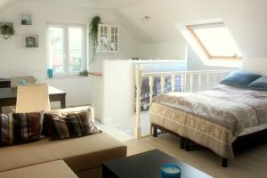 a bedroom with a bed and a couch and a table at Studio Apartment Alba in La Hulpe