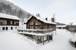 a large wooden house with snow on the roof at Blåstöten Osthang - Ramundberget in Bruksvallarna