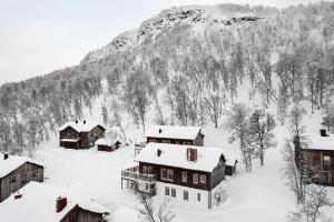 a village covered in snow in front of a mountain at Blåstöten Osthang - Ramundberget in Bruksvallarna