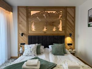 a bedroom with a bed and a wooden headboard at GreenHill Bachleda in Zakopane