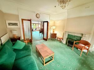 a living room with a green couch and a fireplace at Hylands Hotel Double Room with Shared Bathroom & Free Parking in Nottingham