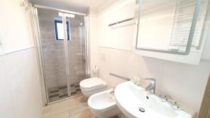 a white bathroom with a sink and a toilet at Verrazzano Family in Lido di Classe +16 photos