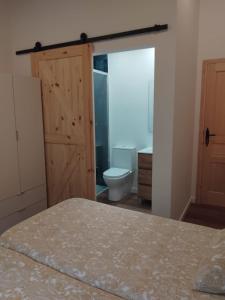 a bedroom with a bed and a bathroom with a toilet at Casa Roda 39 in A Guarda