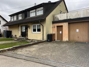 a house with two garage doors and a driveway at Apartments Unterer Kochbuck in Crailsheim