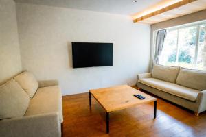 a living room with a couch and a coffee table at バケーションイン伊豆高原 in Ito
