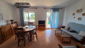 a living room with a table and a blue couch at Chalet Kabesa Peñiscola in Peniscola