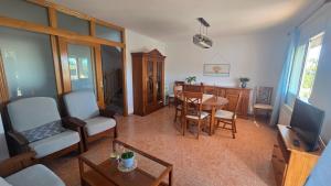 a living room with a table and a dining room at Chalet Kabesa Peñiscola in Peniscola