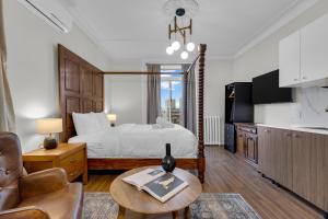 a bedroom with a bed and a couch and a table at Maison Paris- Quartier des Spectacles in Montreal