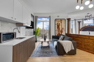 a kitchen and living room with a couch and a table at Maison Paris- Quartier des Spectacles in Montreal
