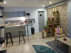 a kitchen with a counter and some chairs and a table at spéculoos et chicorée in Villeneuve d'Ascq