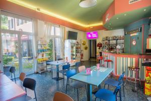 a restaurant with tables and chairs and a counter at Hotel Bello by Ostello Bello in Finale Ligure