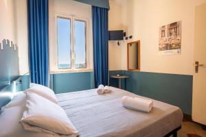 a bedroom with a large bed with towels on it at Hotel Bello by Ostello Bello in Finale Ligure