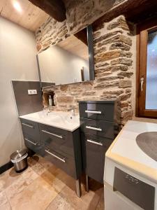 a bathroom with a sink and a stone wall at la grange d'Eugenie in Estaing +13 photos