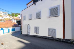 a white building with four windows and a street at Chez Pacha - Dúplex céntrico I 2' playa I hasta 5 huéspedes I equipado I Brava Experience in Cadaqués