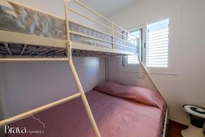 a bunk bed in a small room with a bunk bed underneath a ladder at Chez Pacha - Dúplex céntrico I 2' playa I hasta 5 huéspedes I equipado I Brava Experience in Cadaqués