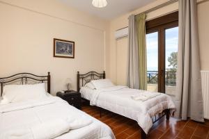 a bedroom with two beds and a window with a view at Villa Rosemary - Luxury Nature Escape in Roussospítion +42 photos