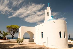 a white church with a cross on the top at Gorgyra - Boutique Apartment in Karlovasi