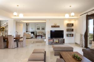 a living room with a television and a dining room at Villa Rosemary - Luxury Nature Escape in Roussospítion