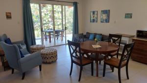 a living room with a wooden table and chairs at Villas Pura Vida - Mango in Puntarenas