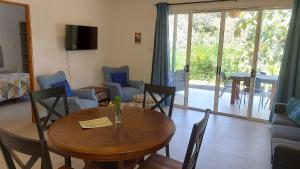 a living room with a wooden table and chairs at Villas Pura Vida - Mango in Puntarenas